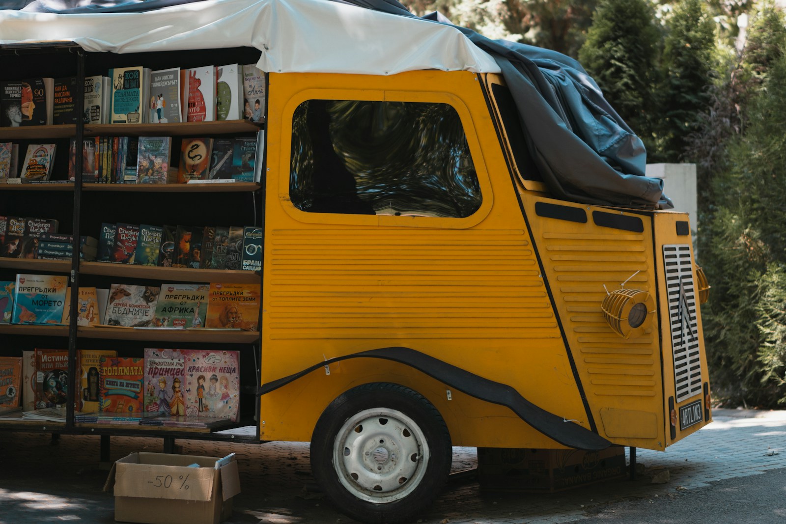 a yellow truck parked next to a bookshelf filled with books